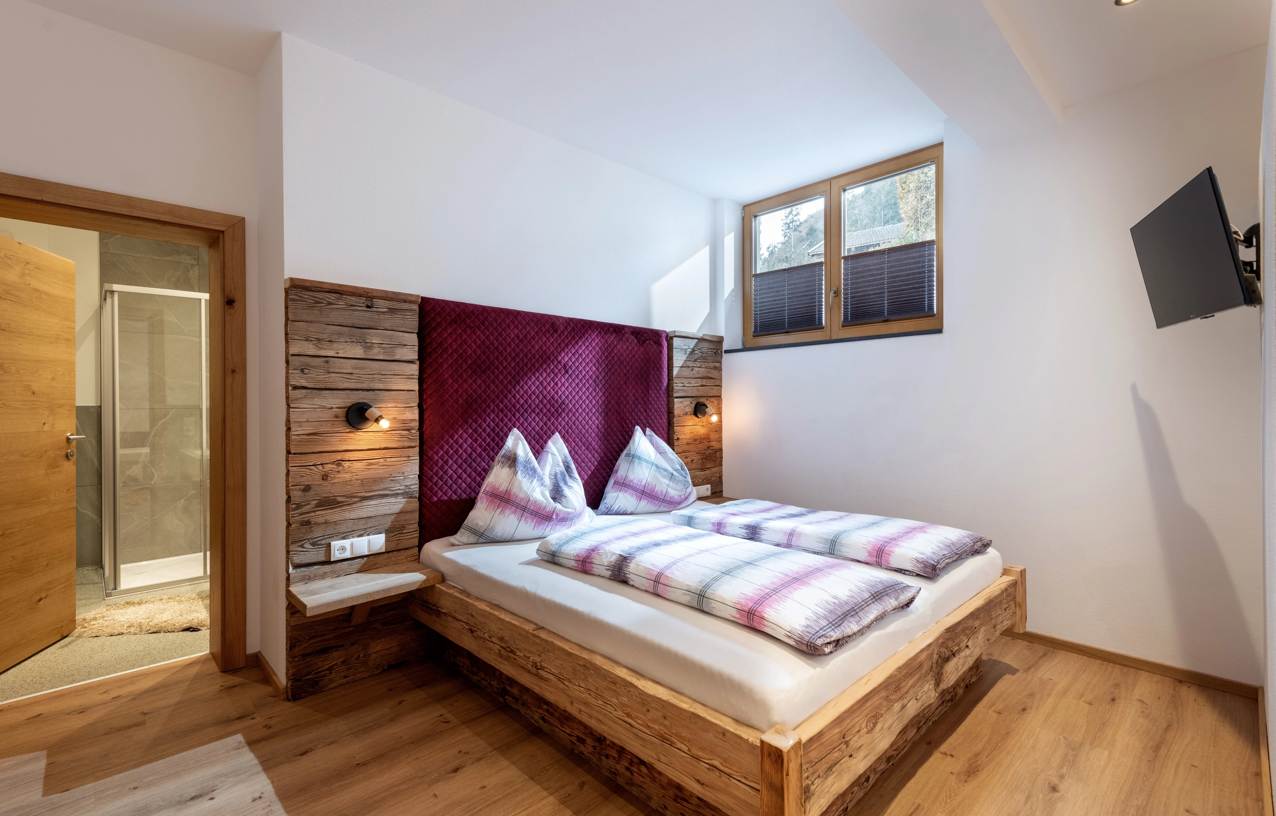 Schlafzimmer mit Doppelbett und TV