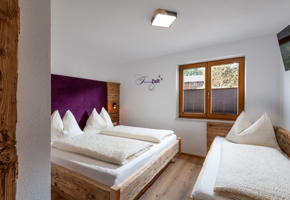 Helles Schlafzimmer mit Doppelbett und Einzelbett