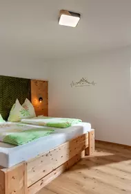 Schlafzimmer mit Doppelbett, Schreibtisch und TV