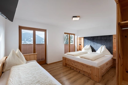 Helles Schlafzimmer mit Doppelbett und Einzelbett