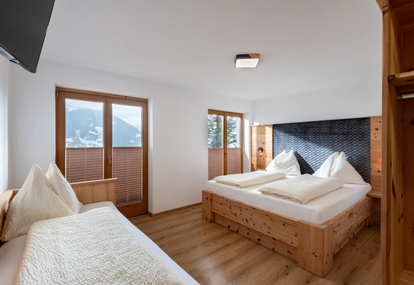 Helles Schlafzimmer mit Doppelbett und Einzelbett