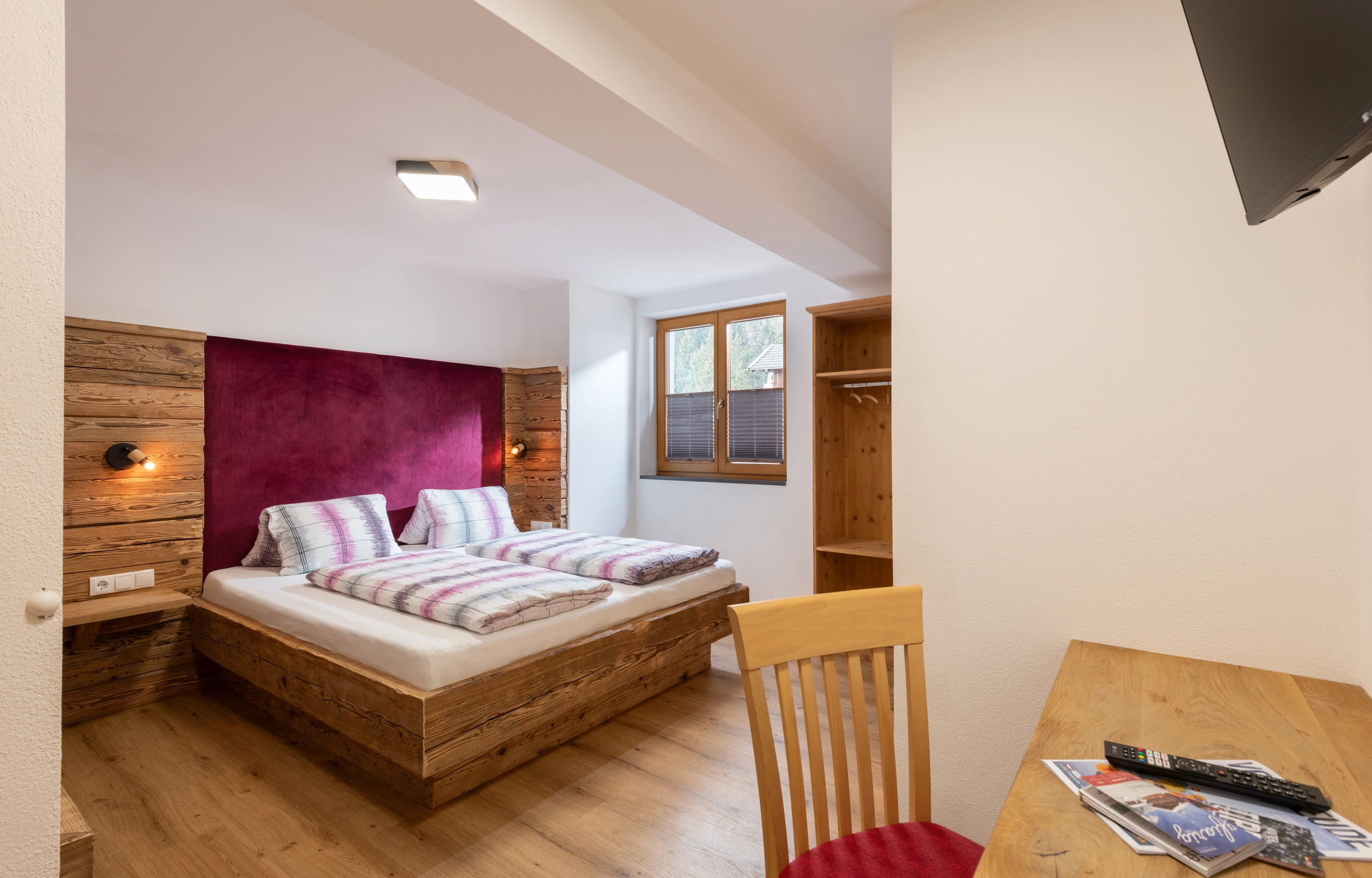 Schlafzimmer mit Doppelbett und TV